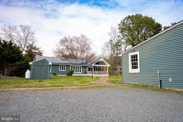 exterior space featuring solar panels and a front yard