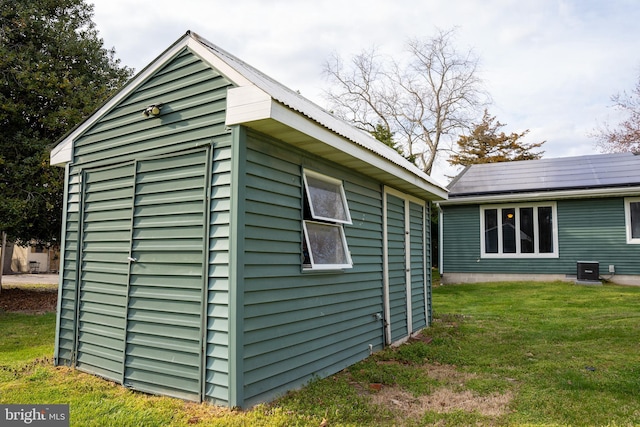 view of side of property with a lawn and a storage unit