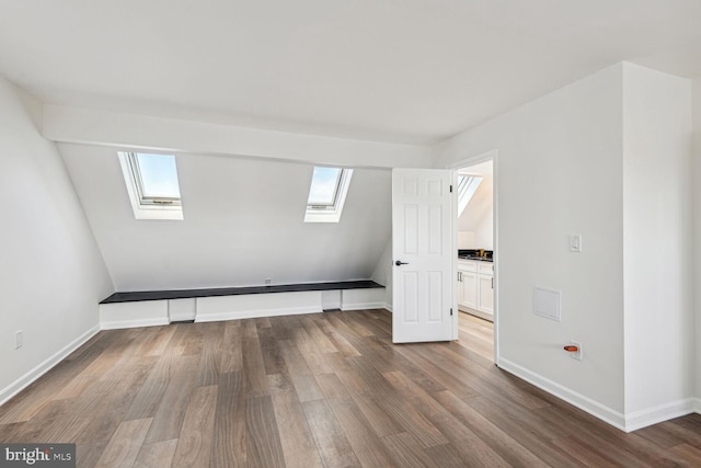 bonus room featuring hardwood / wood-style flooring and a skylight