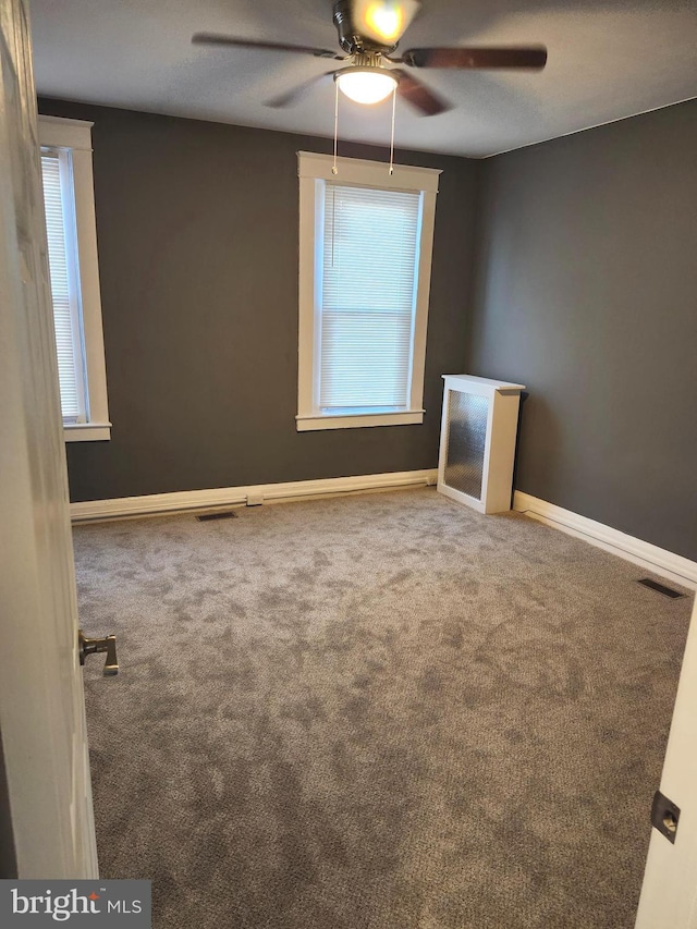 spare room with carpet, ceiling fan, and a wealth of natural light