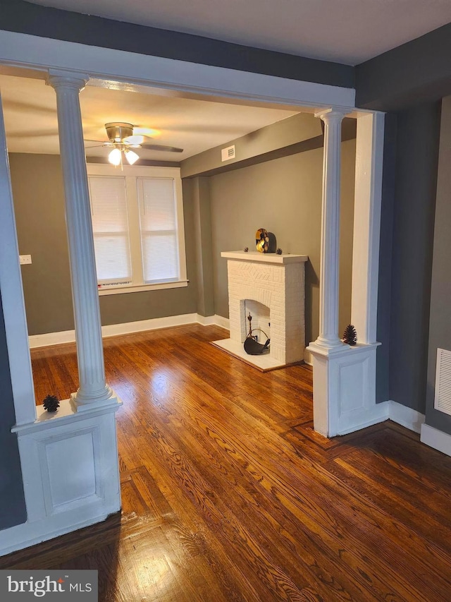 unfurnished living room with a fireplace, dark hardwood / wood-style flooring, and ceiling fan