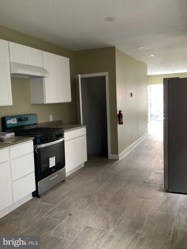 kitchen with white cabinets, refrigerator, and stainless steel gas stove