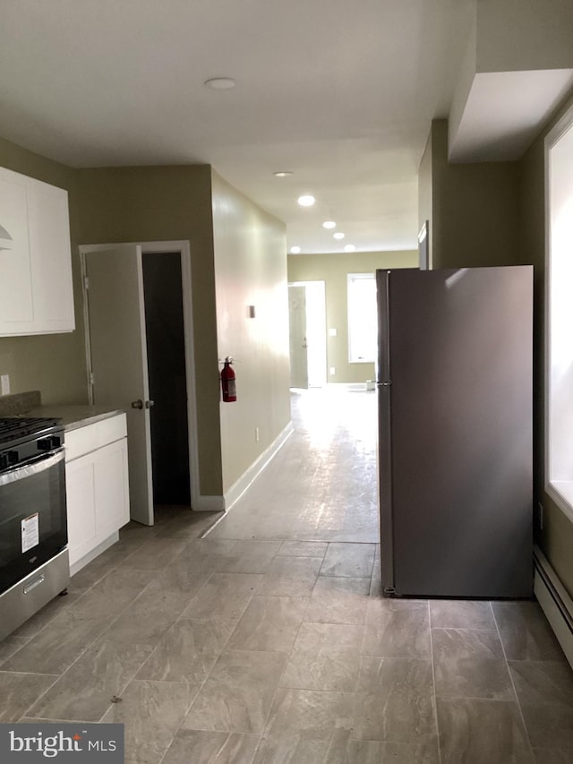 kitchen featuring stainless steel appliances, white cabinetry, and a baseboard radiator