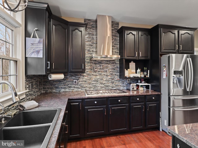 kitchen with wall chimney exhaust hood, sink, stainless steel appliances, and tasteful backsplash