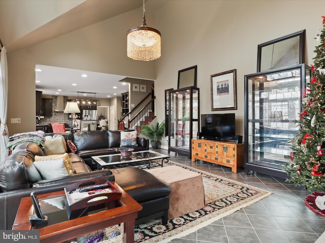 tiled living room with high vaulted ceiling and an inviting chandelier