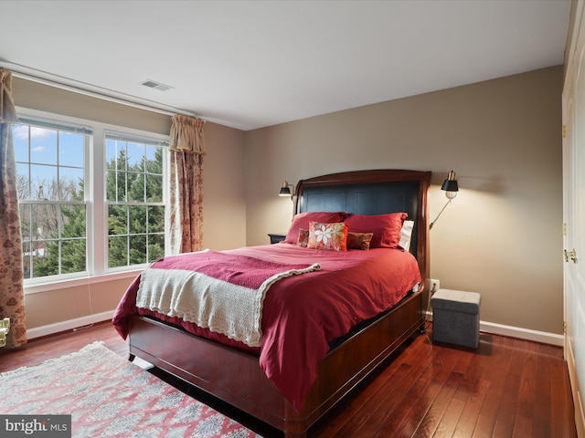 bedroom with multiple windows and dark wood-type flooring