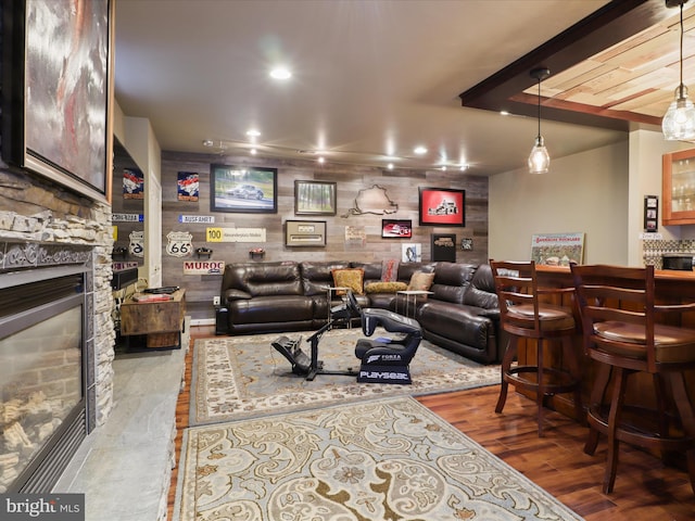 living room featuring a fireplace, bar area, and light hardwood / wood-style flooring