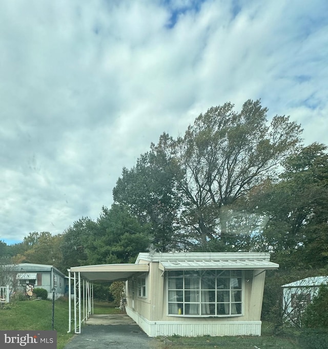 view of side of property featuring a yard and a carport