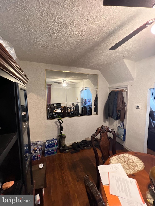 bedroom with lofted ceiling, ceiling fan, a textured ceiling, and hardwood / wood-style flooring