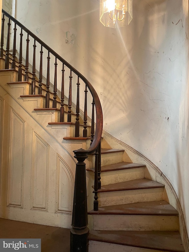 staircase with a chandelier