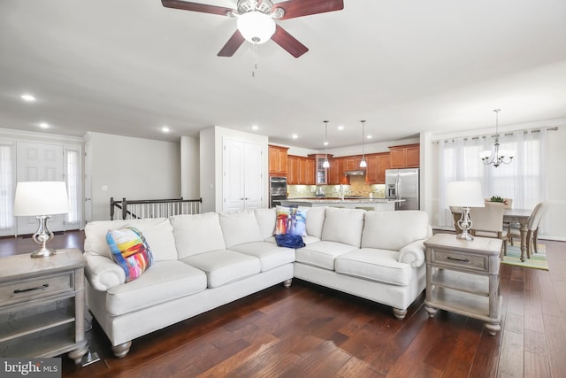 living room featuring dark hardwood / wood-style floors and ceiling fan with notable chandelier