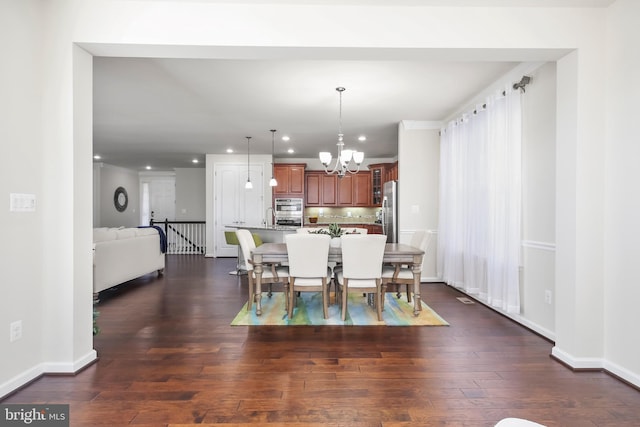 dining space featuring dark hardwood / wood-style flooring and a chandelier