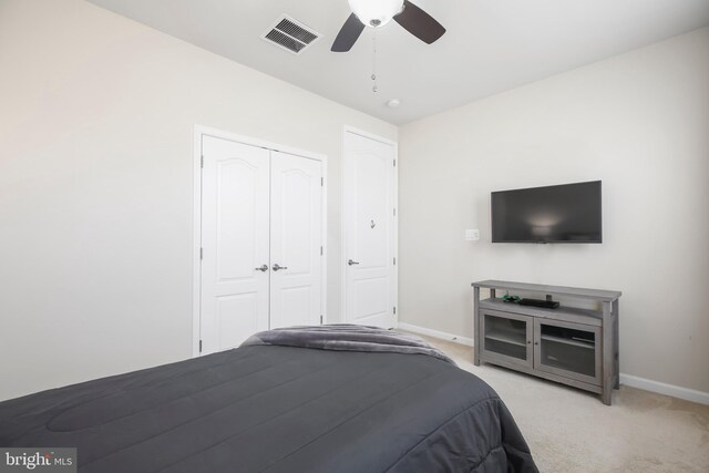 unfurnished bedroom featuring ceiling fan, a closet, and light colored carpet