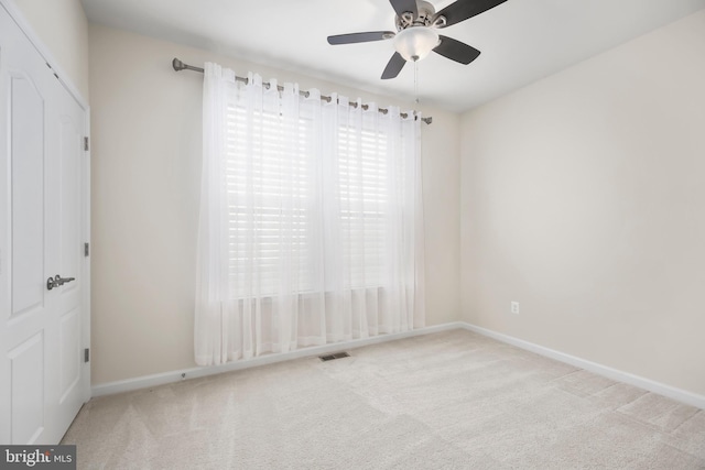 unfurnished room with ceiling fan and light carpet