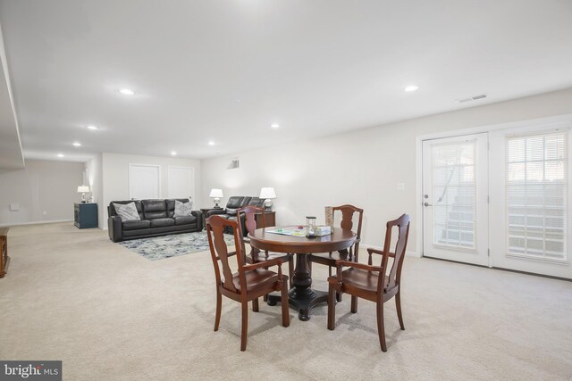 dining space featuring light carpet