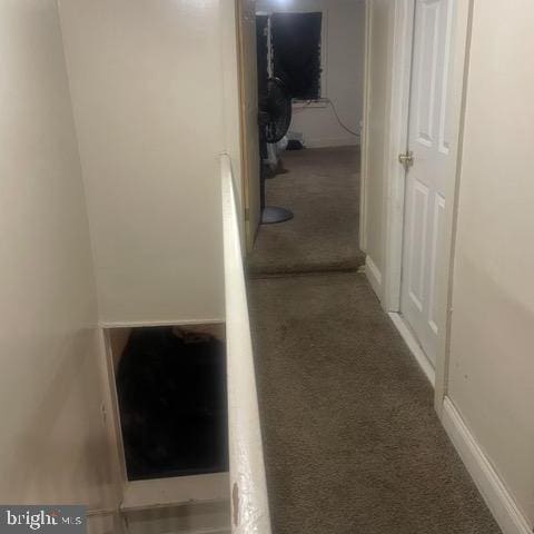 hallway featuring carpet flooring and baseboards