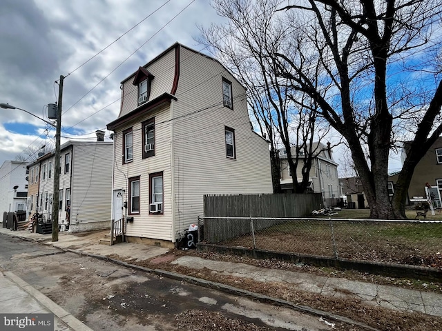 view of side of property featuring cooling unit, fence, a residential view, and entry steps