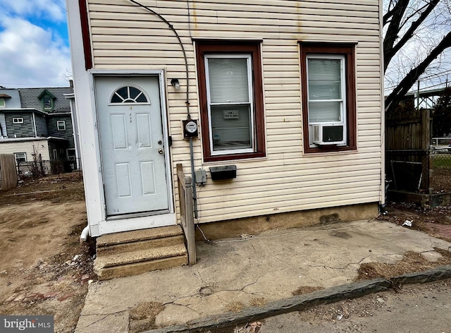 property entrance featuring cooling unit and fence