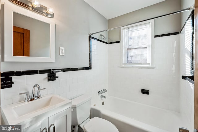 full bathroom with vanity, tiled shower / bath, decorative backsplash, toilet, and tile walls