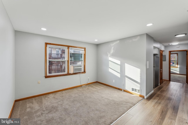 unfurnished room with cooling unit and wood-type flooring