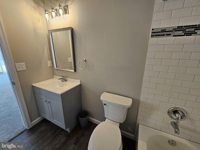 full bathroom featuring toilet, tiled shower / bath combo, hardwood / wood-style floors, and vanity