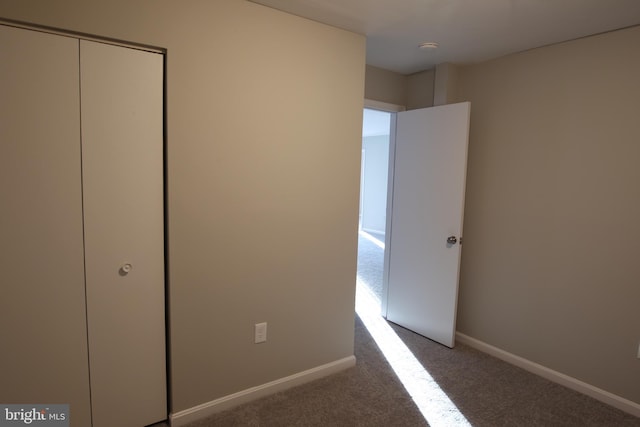 unfurnished bedroom with a closet and carpet flooring