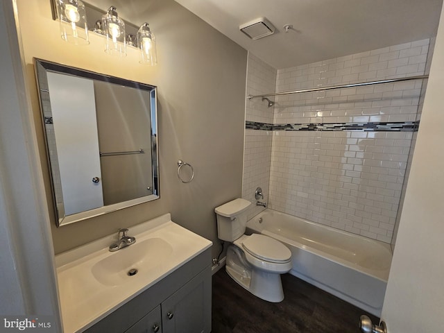 full bathroom featuring toilet, vanity, hardwood / wood-style floors, and tiled shower / bath