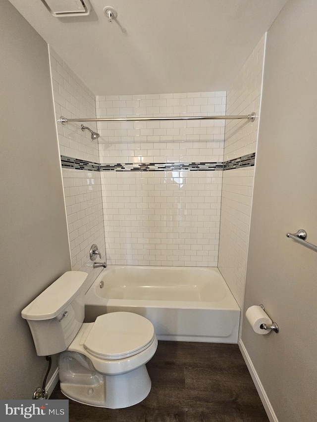 bathroom with toilet, hardwood / wood-style flooring, and tiled shower / bath