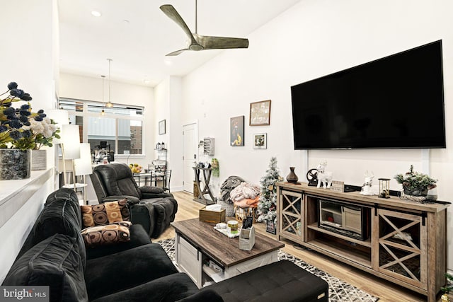 living room with light hardwood / wood-style floors and ceiling fan