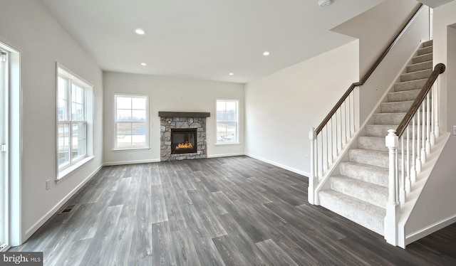 unfurnished living room with a fireplace and dark wood-type flooring