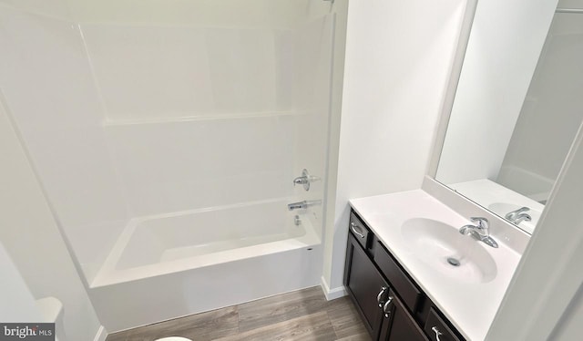 bathroom featuring hardwood / wood-style flooring, vanity, and shower / bathing tub combination