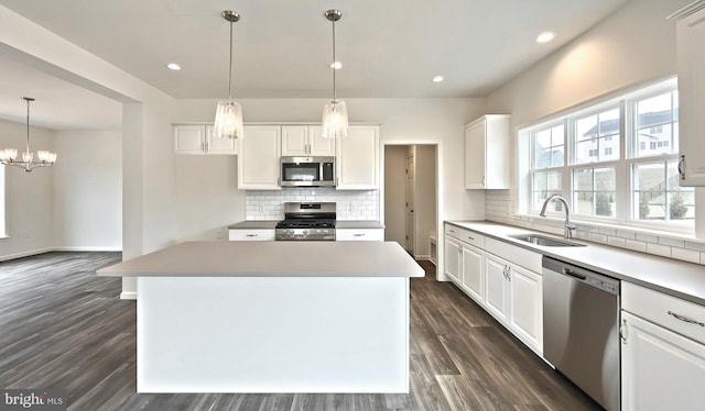 kitchen featuring a kitchen island, white cabinetry, sink, and appliances with stainless steel finishes