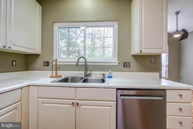 kitchen with stainless steel dishwasher, pendant lighting, white cabinets, and sink