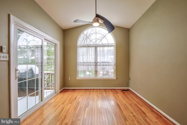 empty room featuring ceiling fan, light hardwood / wood-style floors, and vaulted ceiling