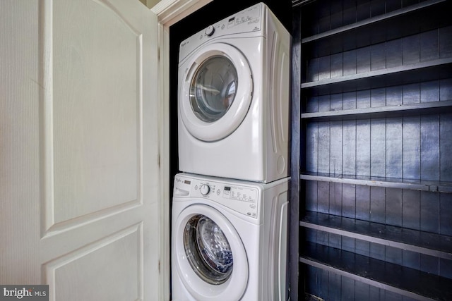 clothes washing area featuring stacked washer and clothes dryer