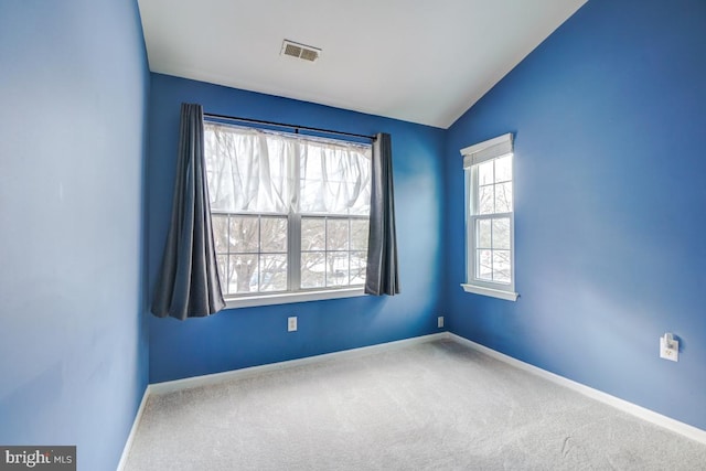 empty room featuring carpet flooring and lofted ceiling