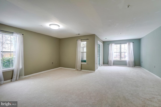 unfurnished room with plenty of natural light and light colored carpet