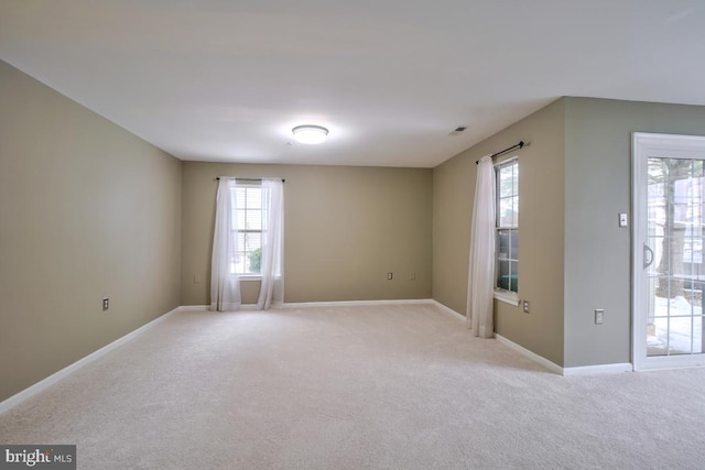 carpeted spare room with a healthy amount of sunlight