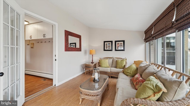 living room with light wood-type flooring and a baseboard heating unit