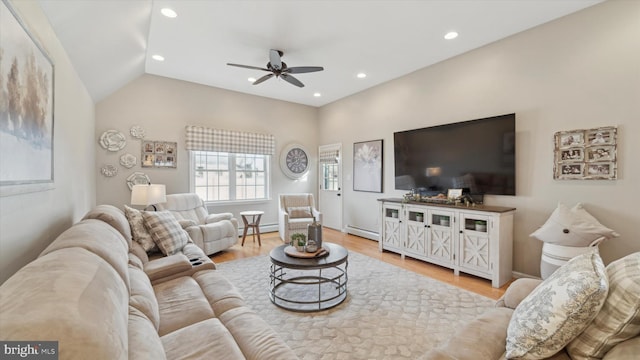 living room with a baseboard radiator, vaulted ceiling, ceiling fan, and light hardwood / wood-style floors