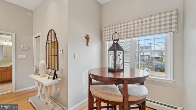 dining room featuring baseboard heating and light hardwood / wood-style flooring