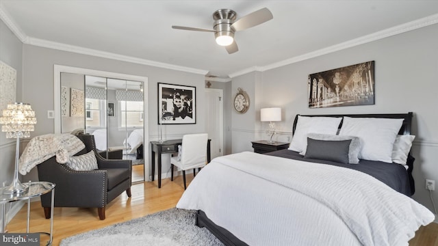 bedroom featuring a closet, hardwood / wood-style floors, ceiling fan, and crown molding