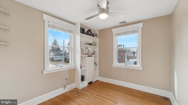 empty room featuring ceiling fan, a wealth of natural light, and light hardwood / wood-style flooring