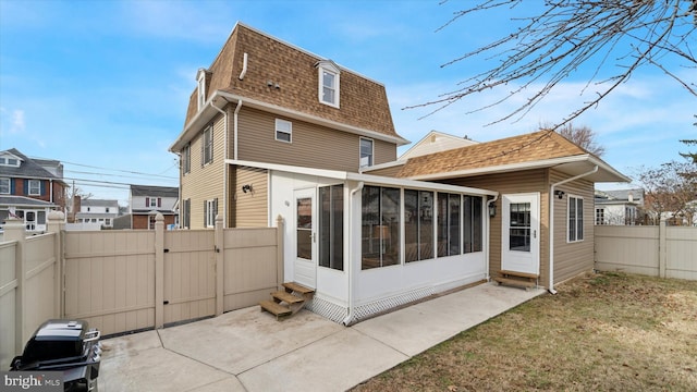 back of property featuring a lawn and a sunroom