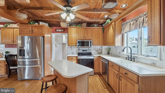 kitchen with stainless steel appliances, sink, wooden ceiling, beamed ceiling, and light hardwood / wood-style floors