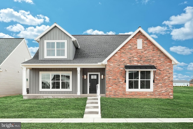 view of front of home featuring board and batten siding, brick siding, and a front lawn