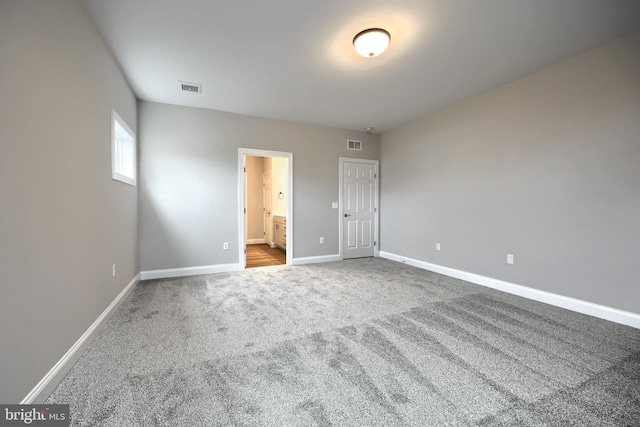 unfurnished bedroom featuring carpet flooring and ensuite bath