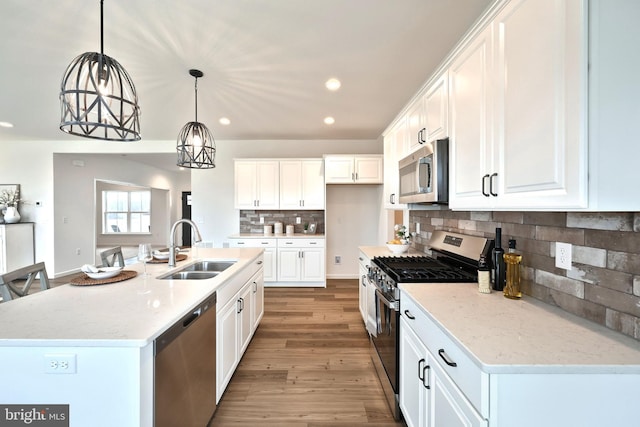 kitchen with stainless steel appliances, white cabinetry, and sink