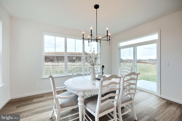 dining space featuring light hardwood / wood-style floors and a chandelier