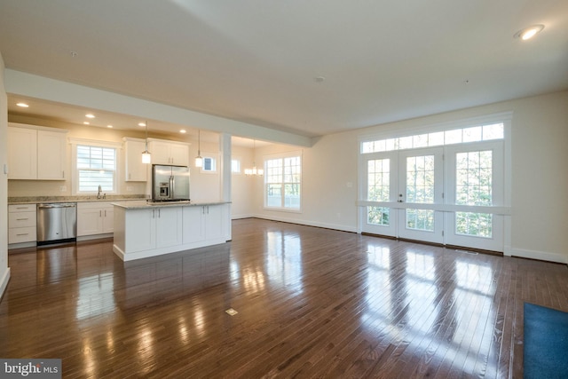 unfurnished living room featuring sink, dark hardwood / wood-style floors, and an inviting chandelier